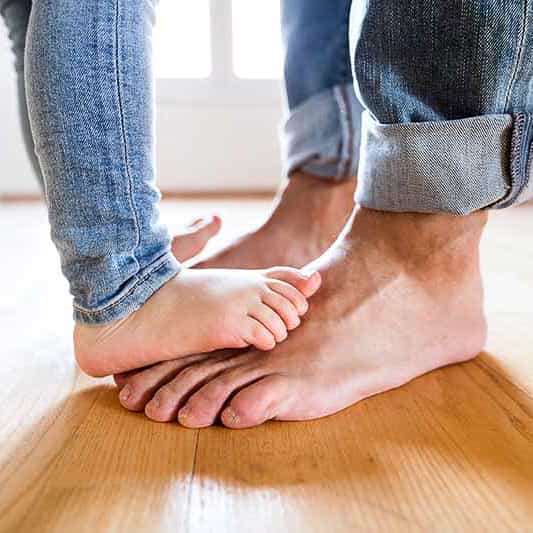 Beautiful young family. Bare feet of father and daughter.